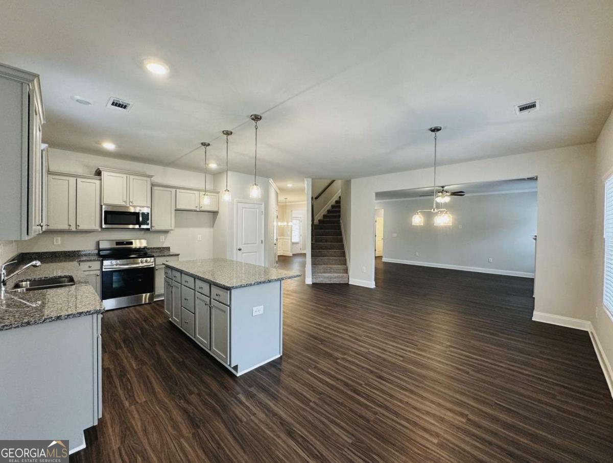 59 Observation Court, Unit 129 Dallas, GA 30132 - Photo 6 of 22 a kitchen with stainless steel appliances granite countertop a refrigerator a stove and a wooden floors