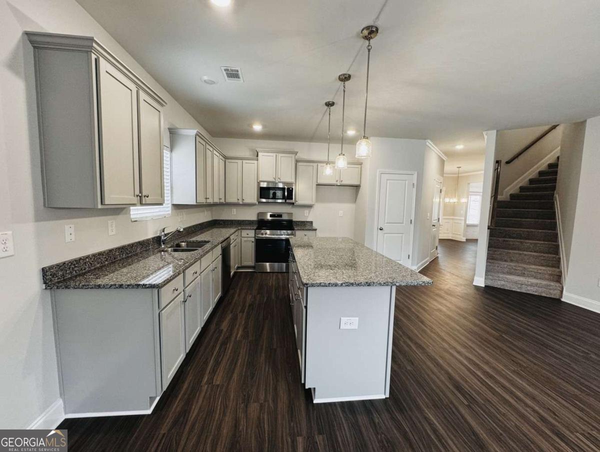 59 Observation Court, Unit 129 Dallas, GA 30132 - Photo 9 of 22 a kitchen with stainless steel appliances granite countertop wooden floors and sink