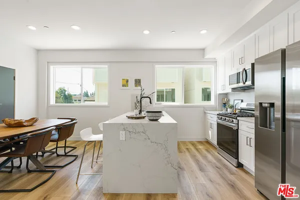 a kitchen with stainless steel appliances kitchen island granite countertop a stove a sink a refrigerator and island