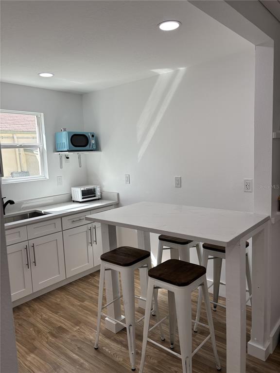 14141 Gulf Boulevard, Unit 5 Madeira Beach, FL 33708 - Photo 3 of 14 a kitchen with stainless steel appliances a table and chairs in it