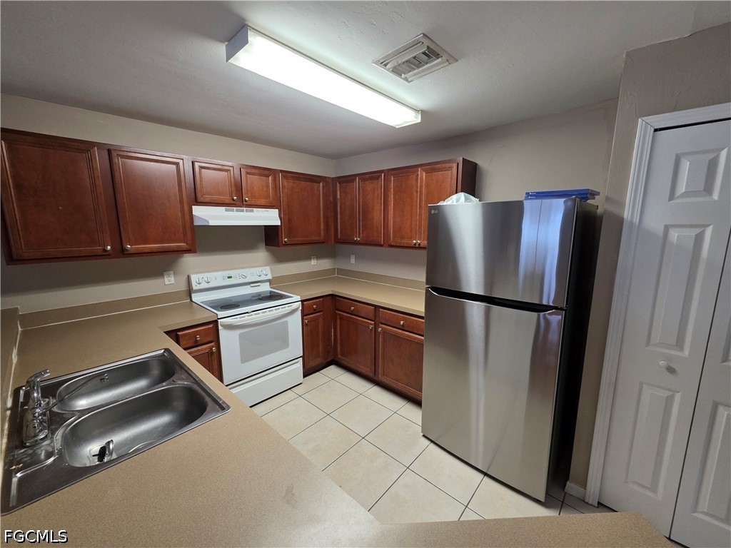 4647 24th Street Southwest Lehigh Acres, FL 33973 - Photo 6 of 12 a kitchen with a refrigerator sink and cabinets