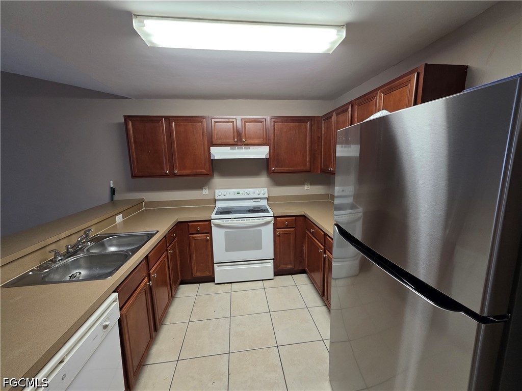 4647 24th Street Southwest Lehigh Acres, FL 33973 - Photo 7 of 12 a kitchen with stainless steel appliances granite countertop a refrigerator a sink and a stove