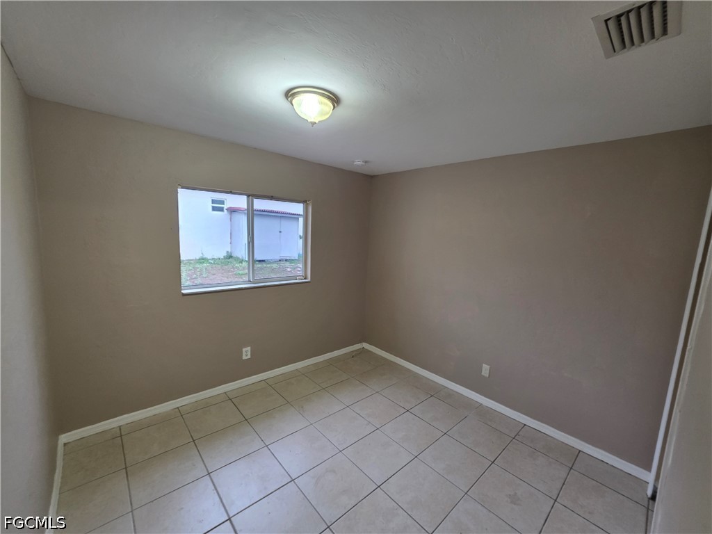 4647 24th Street Southwest Lehigh Acres, FL 33973 - Photo 8 of 12 an empty room with a workbench