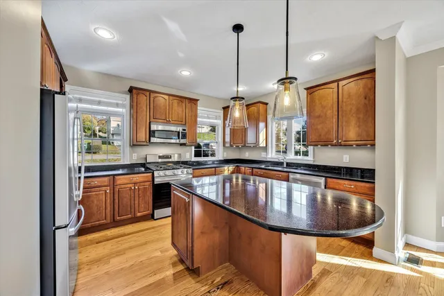 a kitchen with stainless steel appliances granite countertop a sink a stove and a refrigerator
