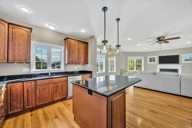 a kitchen with stainless steel appliances granite countertop a sink a stove and a wooden floors
