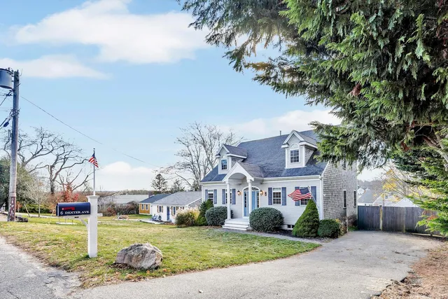 a view of a brick house next to a yard with big trees