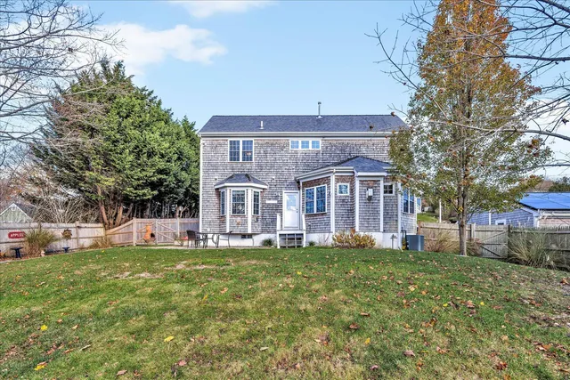 a view of a house with a big yard and large trees