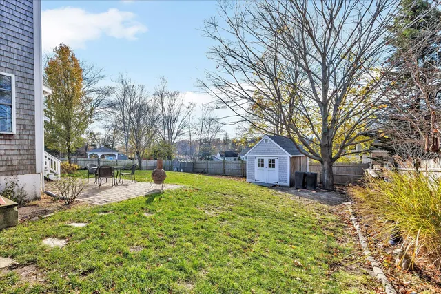 a large tree in front of a brick house