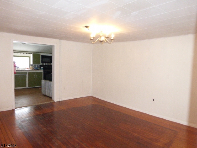 9 New Row Road, Unit A Hibernia, NJ 07842 - Photo 5 of 28 an empty room with wooden floor and kitchen view