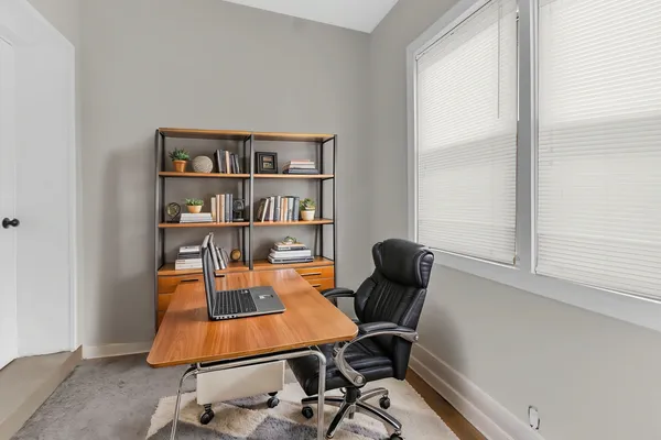 a view of a workspace with furniture and a window