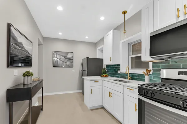 a kitchen with granite countertop a sink stove and cabinets