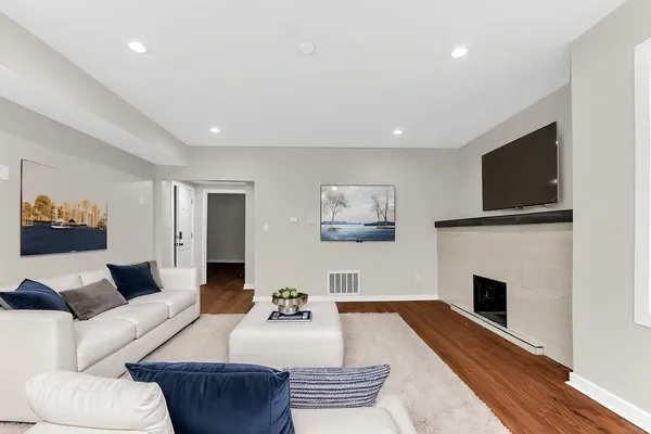 a living room with furniture a flat screen tv and a fireplace