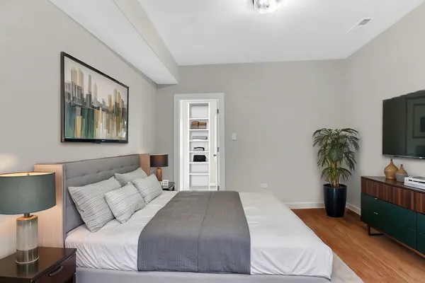 a bedroom with a large bed and a potted plant