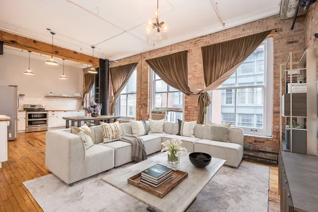 a living room with furniture ceiling fan and a large window