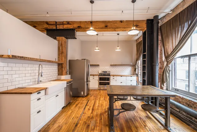 a kitchen with stainless steel appliances granite countertop a sink a stove and a refrigerator