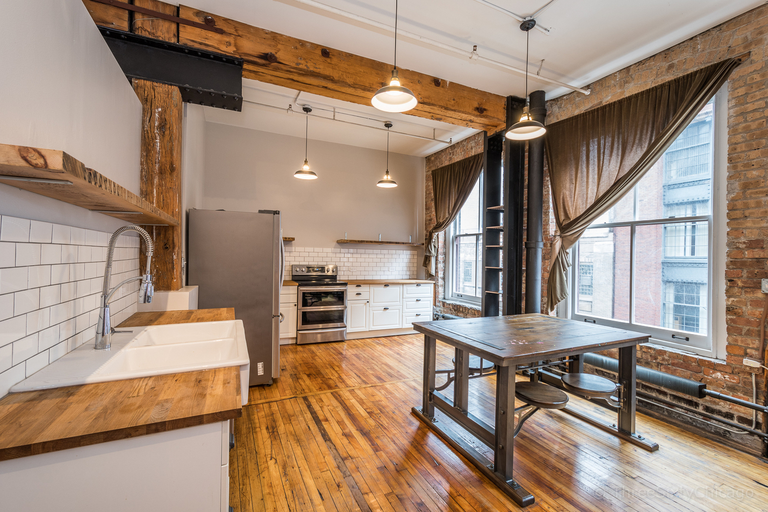 711 South Dearborn Street, Unit 508 Chicago, IL 60605 - Photo 6 of 16 a open kitchen with stainless steel appliances kitchen island granite countertop a table chairs and a wooden floor