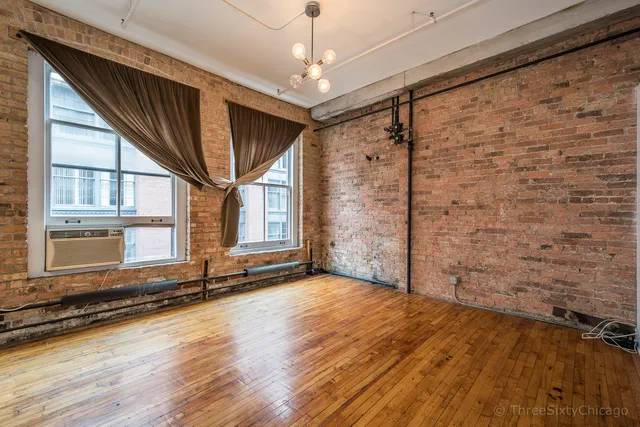 a view of a livingroom with wooden floor and a large window