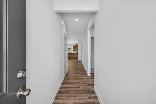 a view of a hallway with wooden floor and entryway