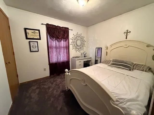 a bedroom with a bed and a wall painting