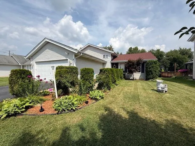 a front view of a house with a garden and plants