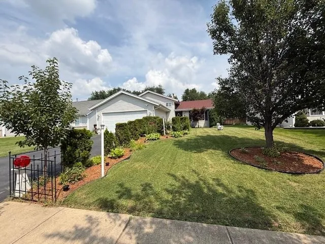 a backyard of a house with table and chairs plants
