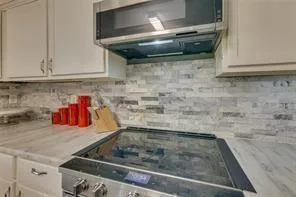 a kitchen with stainless steel appliances kitchen island granite countertop a refrigerator and cabinets