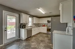 a kitchen with white cabinets and stainless steel appliances