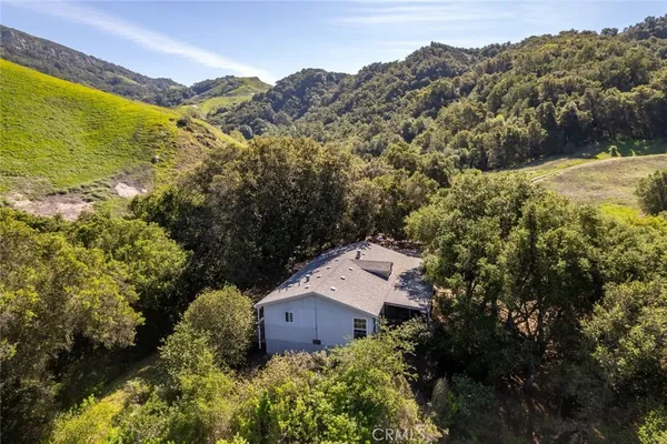 an aerial view of a house with a mountain