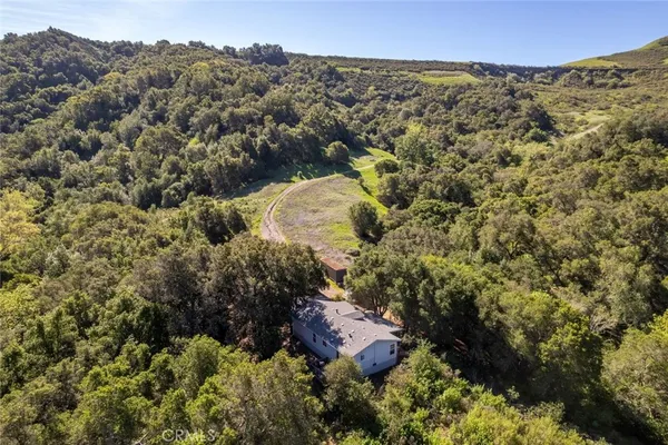 a view of a with a lush green hillside and a houses