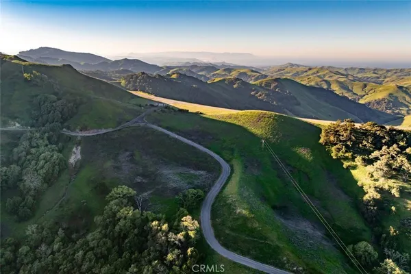 an aerial view of residential houses with outdoor space and trees