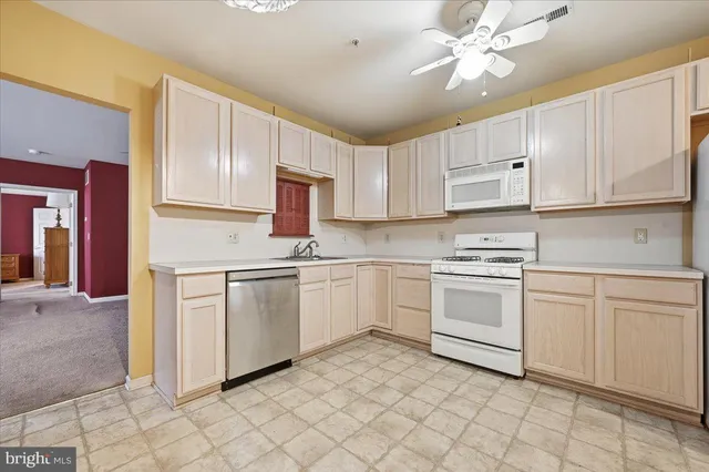 a kitchen with white cabinets appliances and a sink