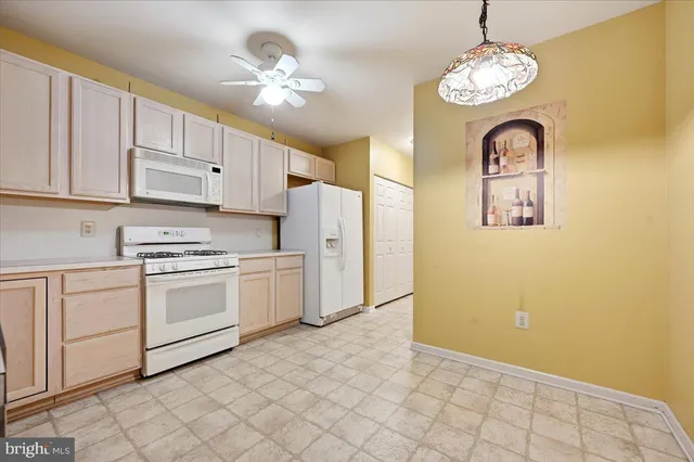 a kitchen with cabinets stainless steel appliances and chandelier