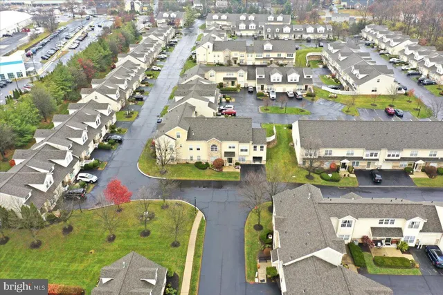 a view of a big house with a big yard and large trees