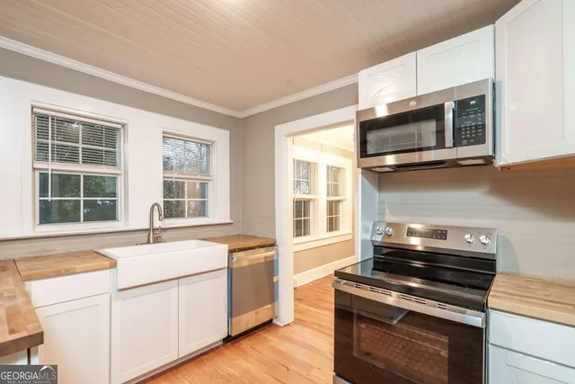 a kitchen with stainless steel appliances a stove sink and microwave