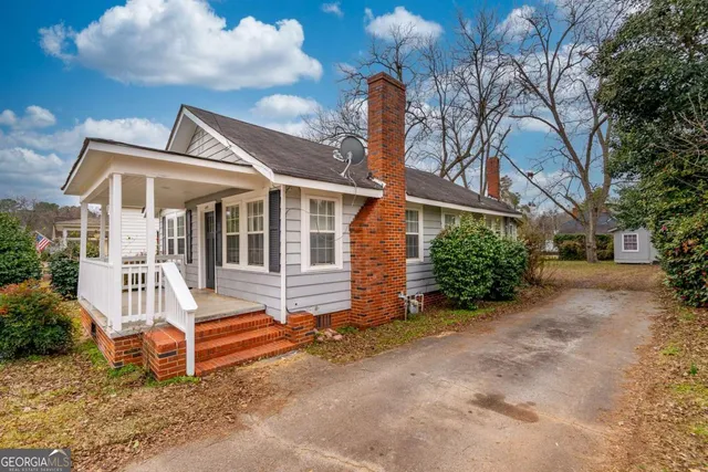 a view of a house with a yard and fence