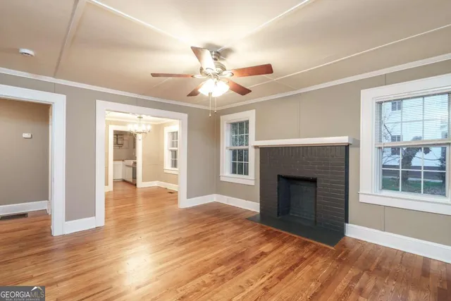 a view of an empty room with window and fire place