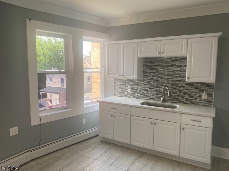 14 Jackson Street, Unit 9 Passaic, NJ 07055 - Photo 2 of 11 a bathroom with a sink a mirror and a window