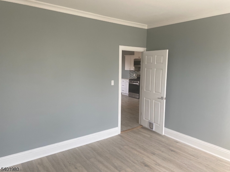 14 Jackson Street, Unit 9 Passaic, NJ 07055 - Photo 6 of 11 a view of an empty room with wooden floor and closet