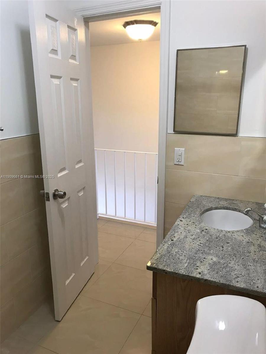 1100 West 35th Street, Unit 27 Hialeah, FL 33012 - Photo 18 of 24 a bathroom with a granite countertop sink and a mirror