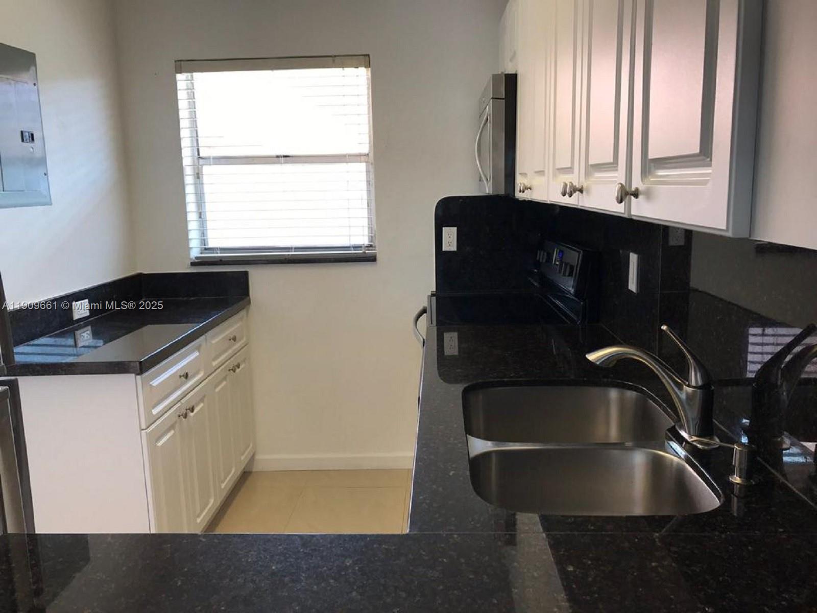 1100 West 35th Street, Unit 27 Hialeah, FL 33012 - Photo 5 of 24 a kitchen with a sink and cabinets