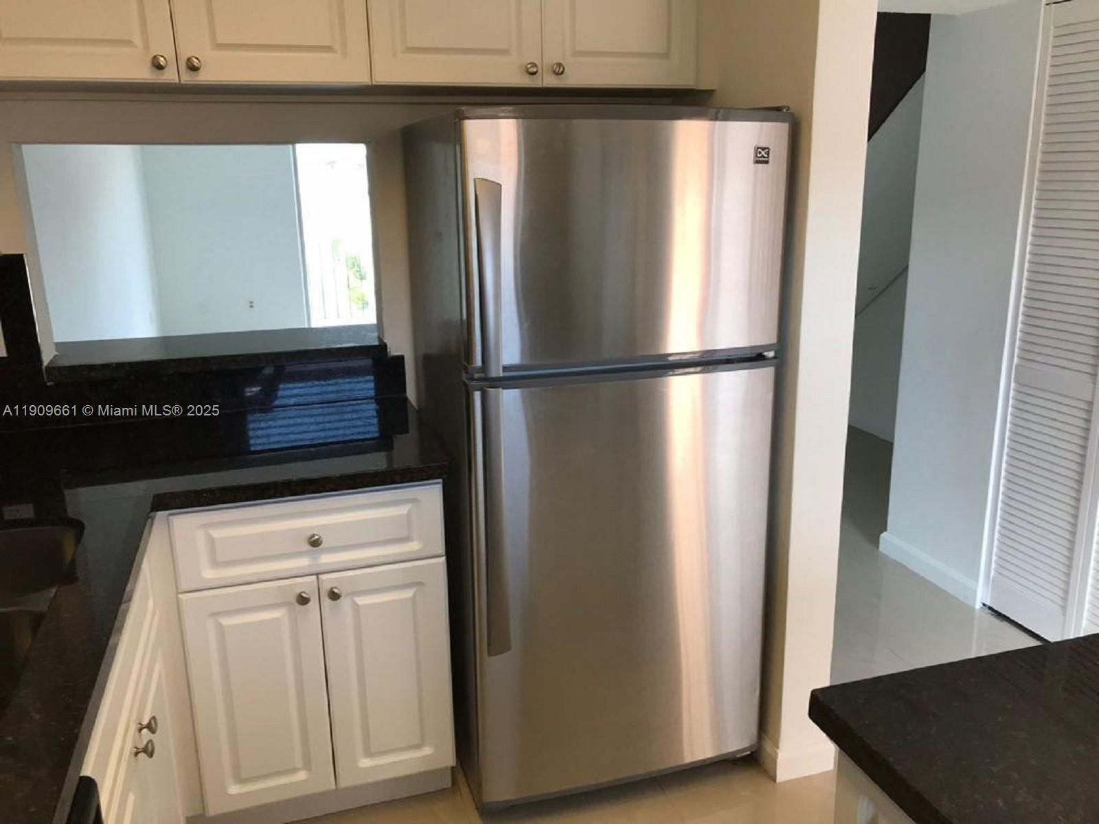 1100 West 35th Street, Unit 27 Hialeah, FL 33012 - Photo 6 of 24 a view of a refrigerator in kitchen and dishwasher with wooden floor