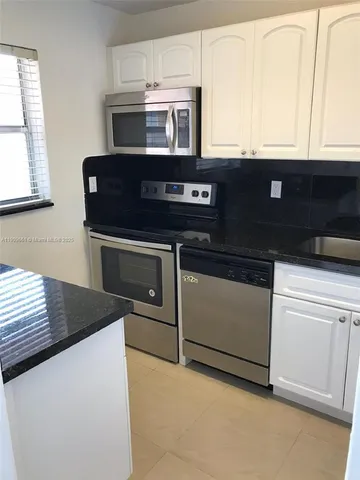 a kitchen with granite countertop a stove and a microwave