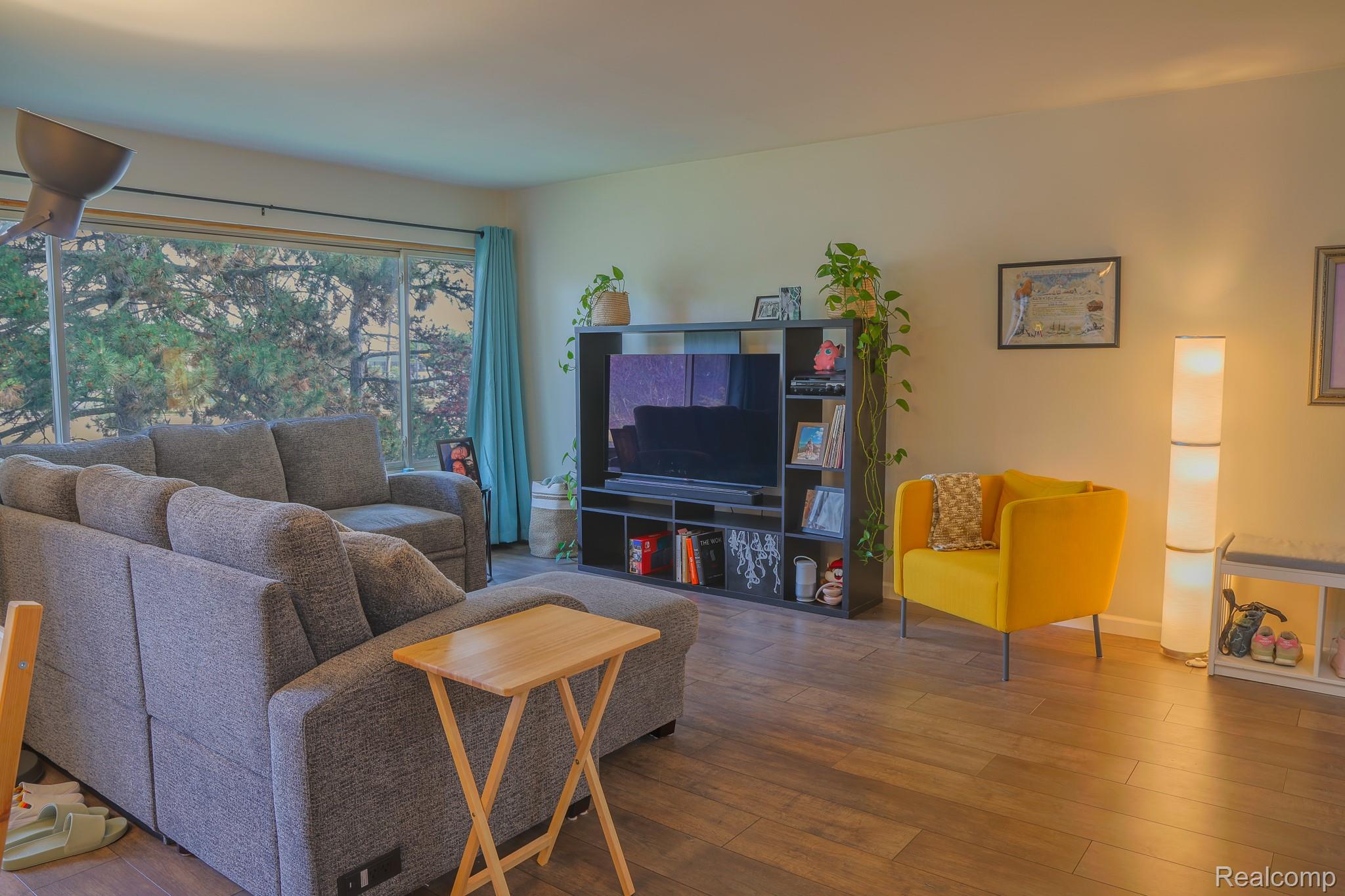 1989 Klingensmith Road, Unit 46 Bloomfield Hills, MI 48302 - Photo 2 of 41 Spacious living area featuring expansive window, wood-finish flooring, and light-toned walls