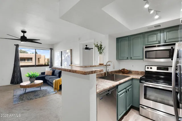 a kitchen with stainless steel appliances granite countertop a refrigerator a sink a stove a microwave and island