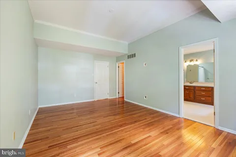 a view of empty room with wooden floor