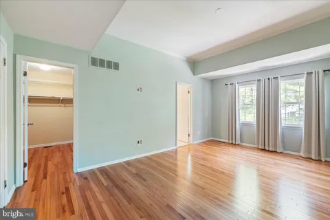 a view of an empty room with wooden floor