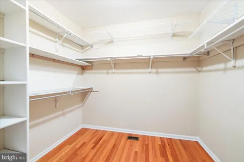a view of walk in closet with empty racks