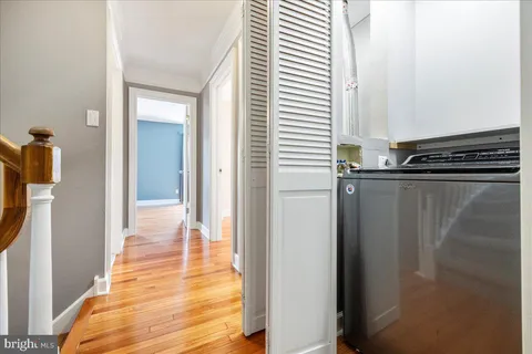 a view of a hallway with wooden floor and staircase