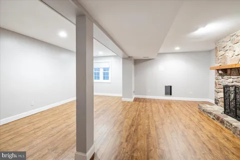 a view of empty room with wooden floor and fireplace