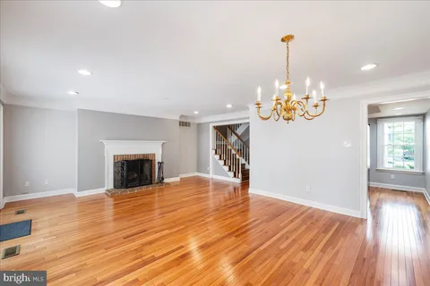 a view of a room with wooden floor fireplace and window